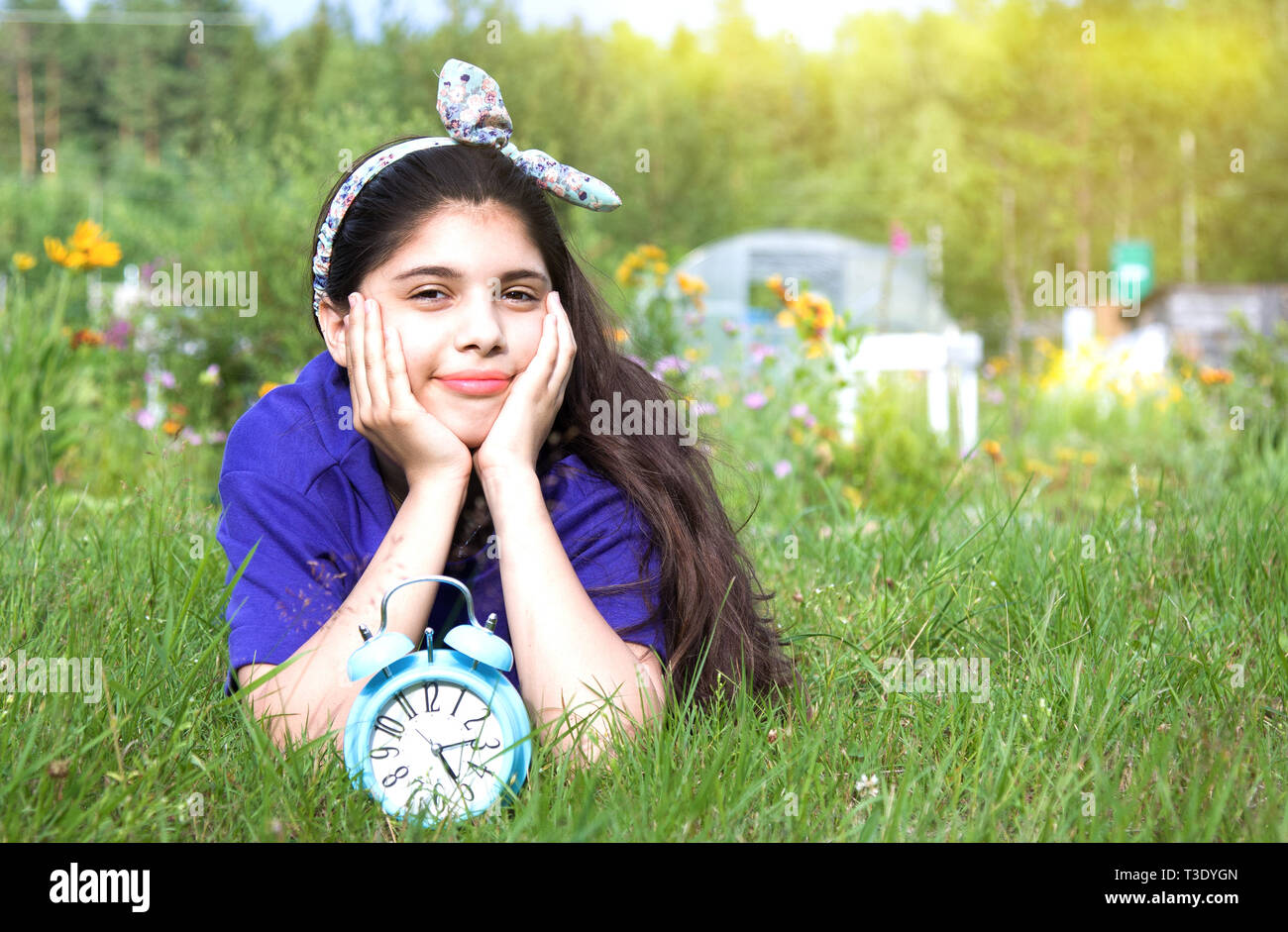 Smiling girl avec réveil en jardin d'été Banque D'Images