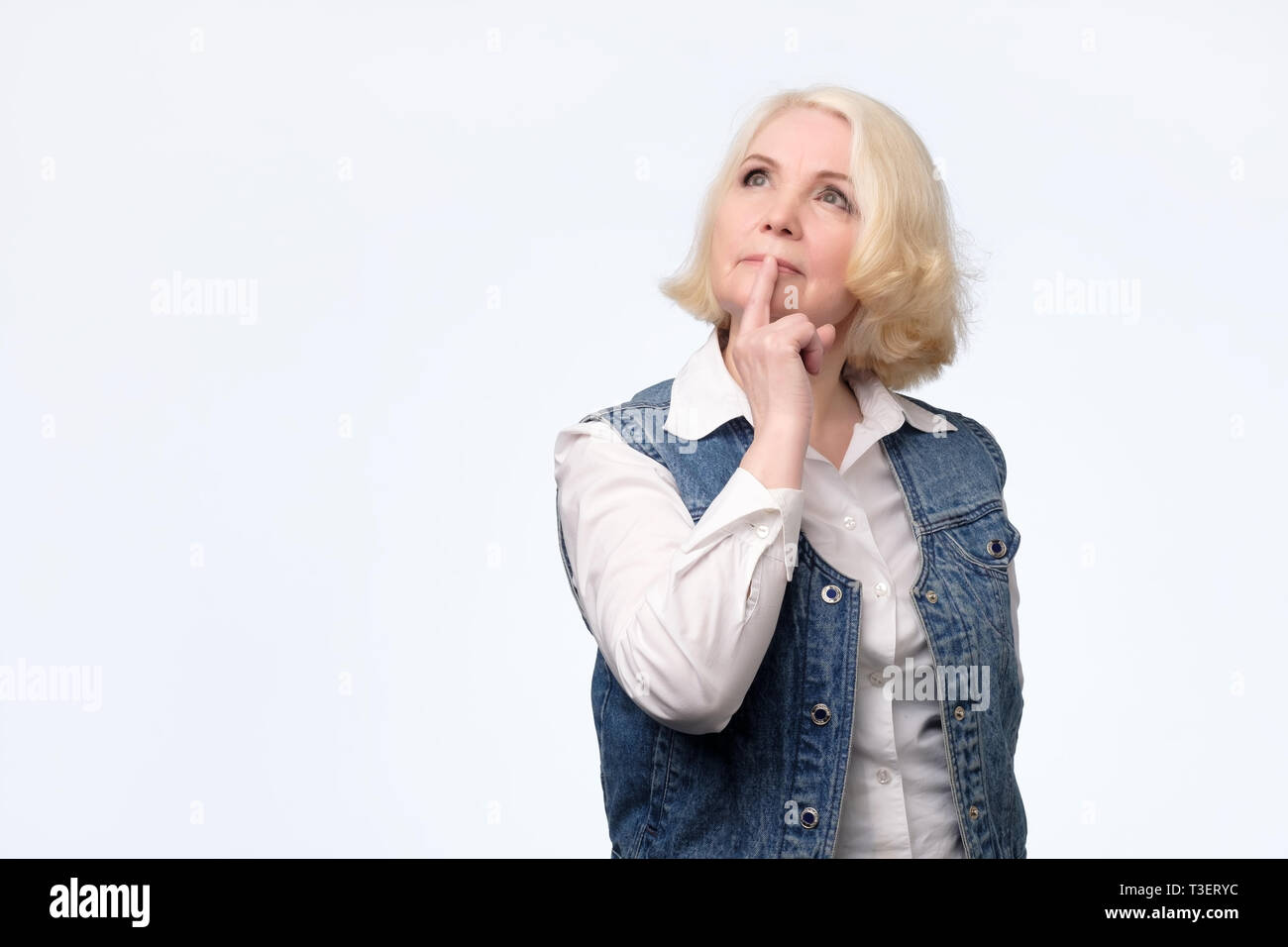 Senior woman sourire essayant de penser créer un plan dans l'esprit Banque D'Images
