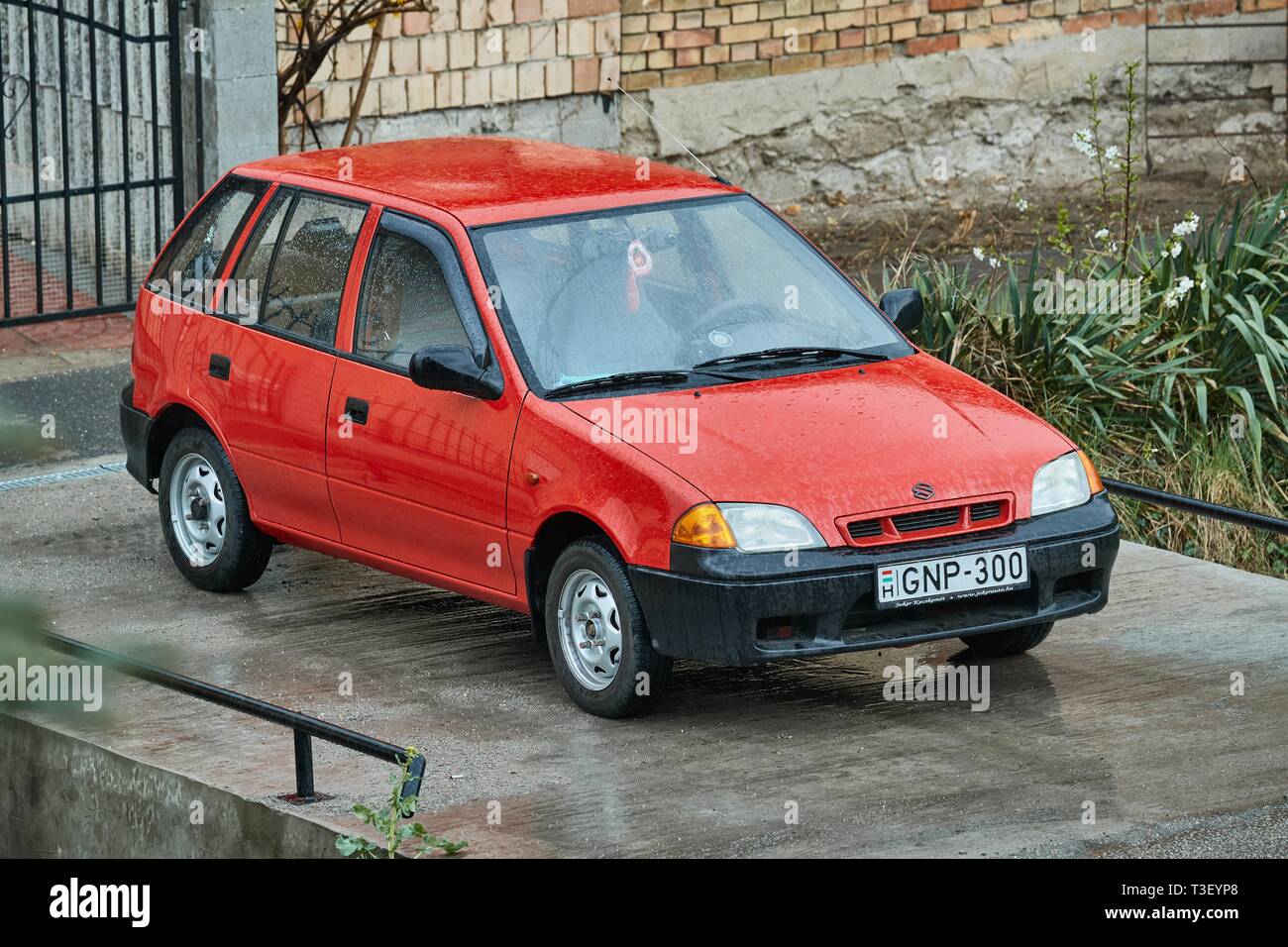 BUDAPEST, HONGRIE - 7 avril, 2019 : Vieille Suzuki Swift garé dans la rue par temps de pluie. Petite voiture populaire faite dans le début de années 90. En Septembe Banque D'Images