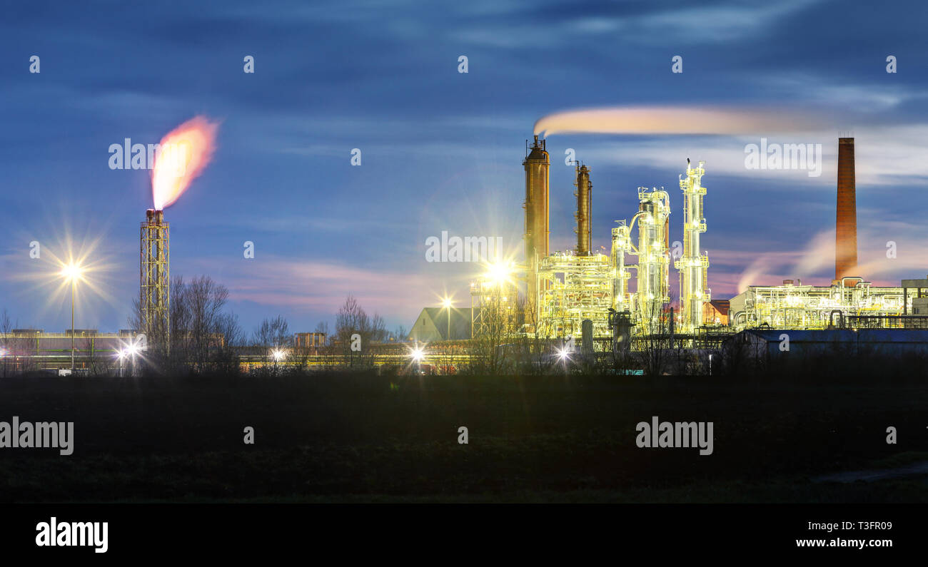 Raffinerie de pétrole dans la nuit avec cheminée Banque D'Images