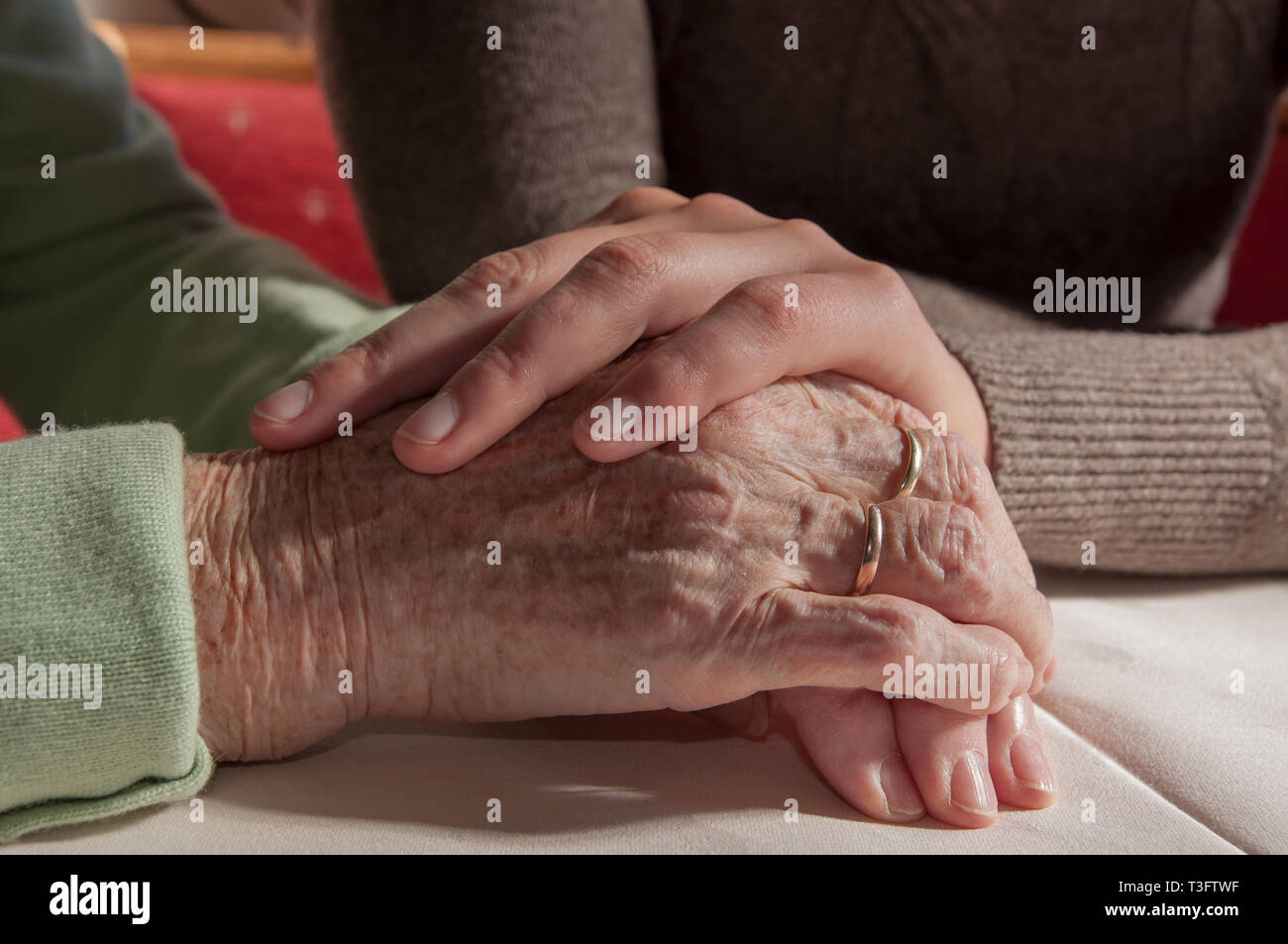 Close up of young woman's hands holding hands of senior woman Banque D'Images
