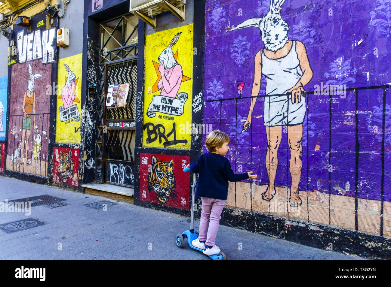 Quartier de la ville Bario Russafa Valencia Ruzafa Valencia Espagne Street Art Graffiti mur mural enfant avec Push Scooter Banque D'Images