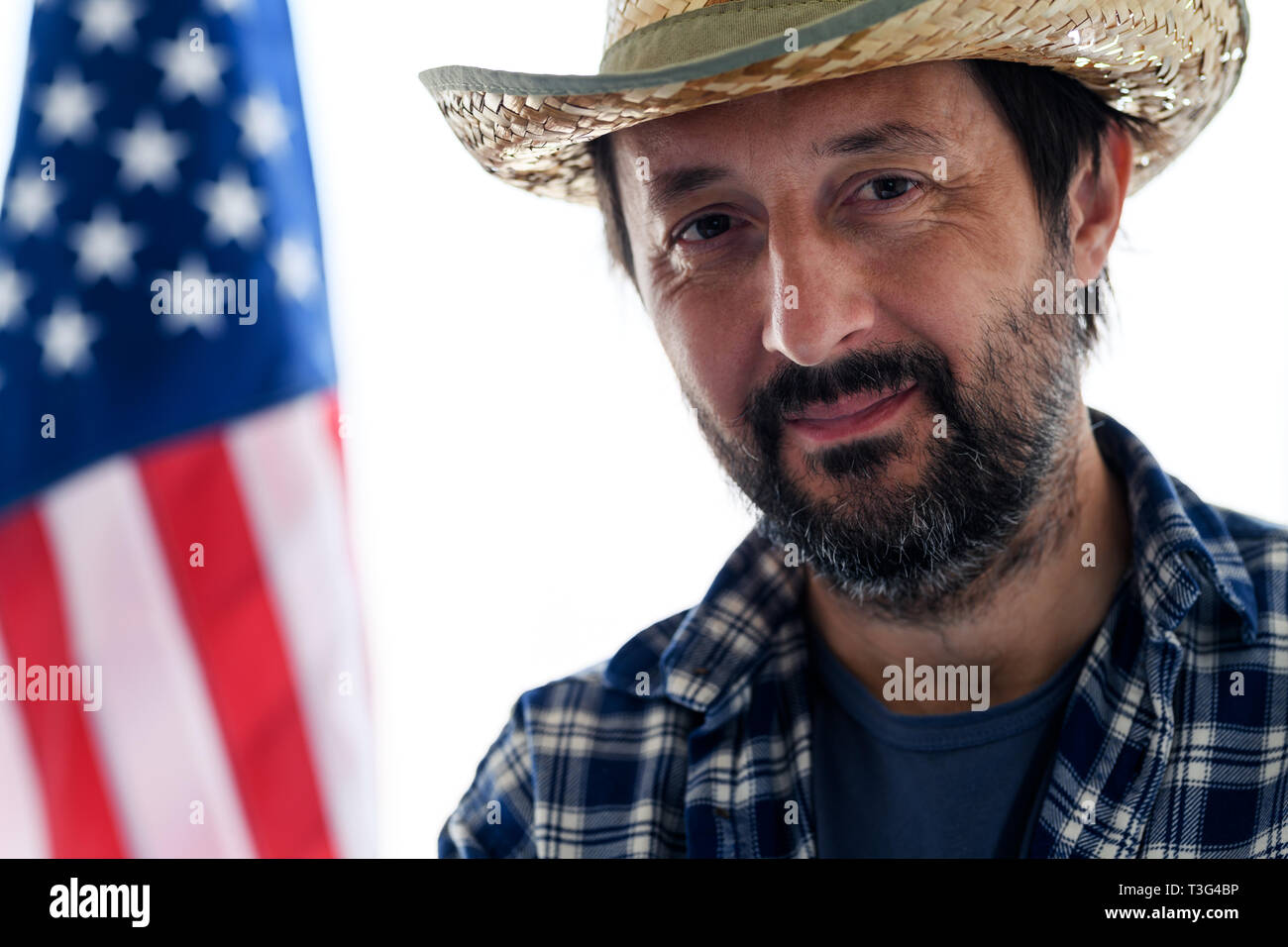 American farmer Smiling, portrait des mâles adultes de personne avec chapeau de paille et chemise à carreaux avec drapeau USA en arrière-plan Banque D'Images