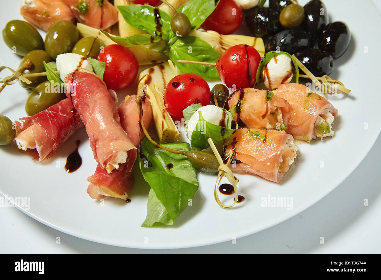 Salade de légumes aux olives, câpres, viande et petits pains. Isolé sur fond blanc. Banque D'Images