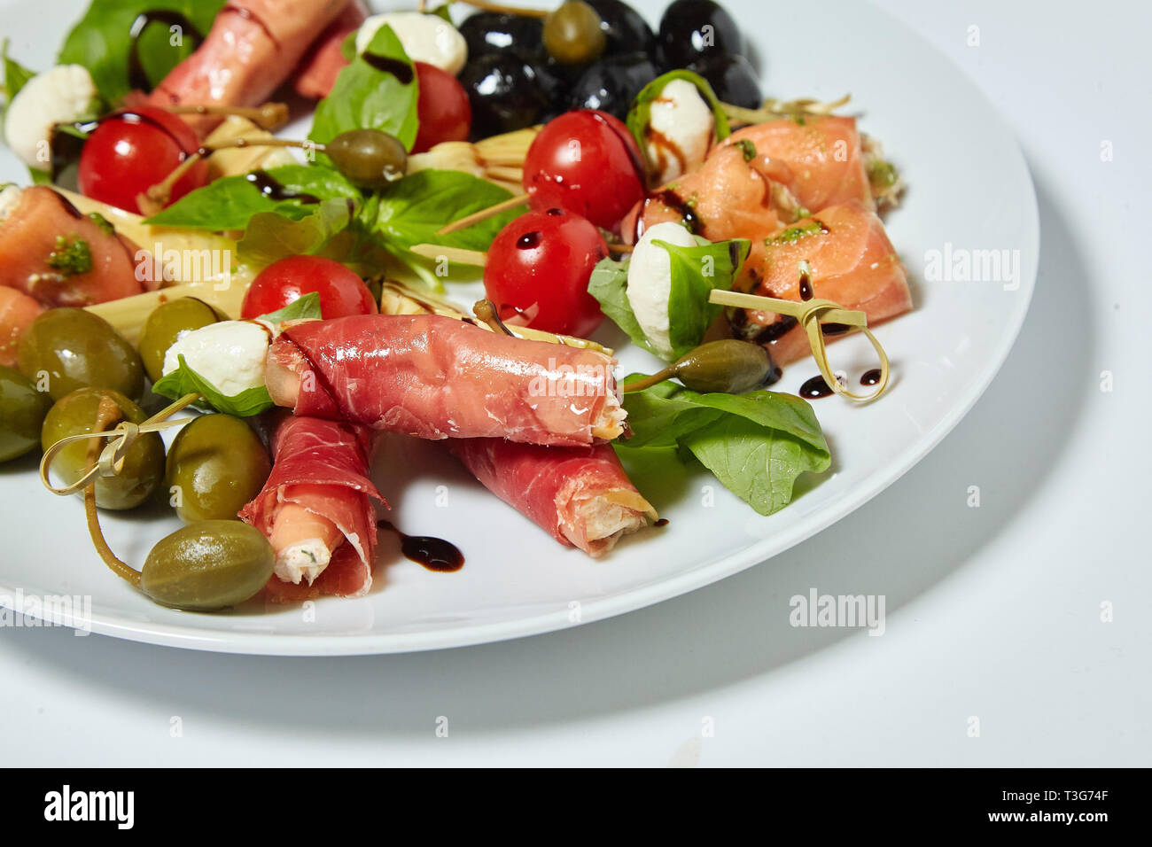 Salade de légumes aux olives, câpres, viande et petits pains. Isolé sur fond blanc. Banque D'Images