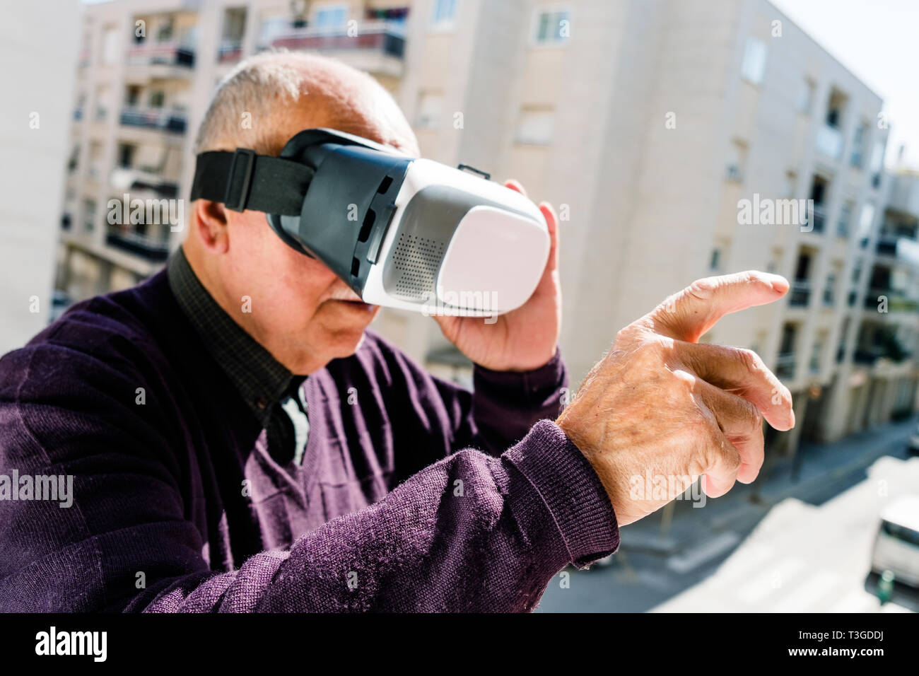 Libre d'un vieil homme de race blanche à l'aide d'un casque de réalité virtuelle à l'extérieur Banque D'Images
