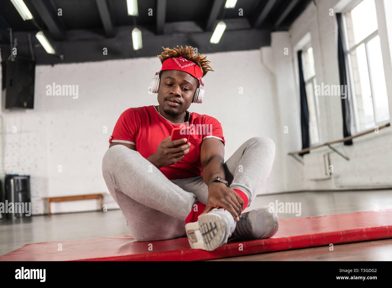 Beau mec sportif avec des dreadlocks court contrôle de médias sociaux Banque D'Images