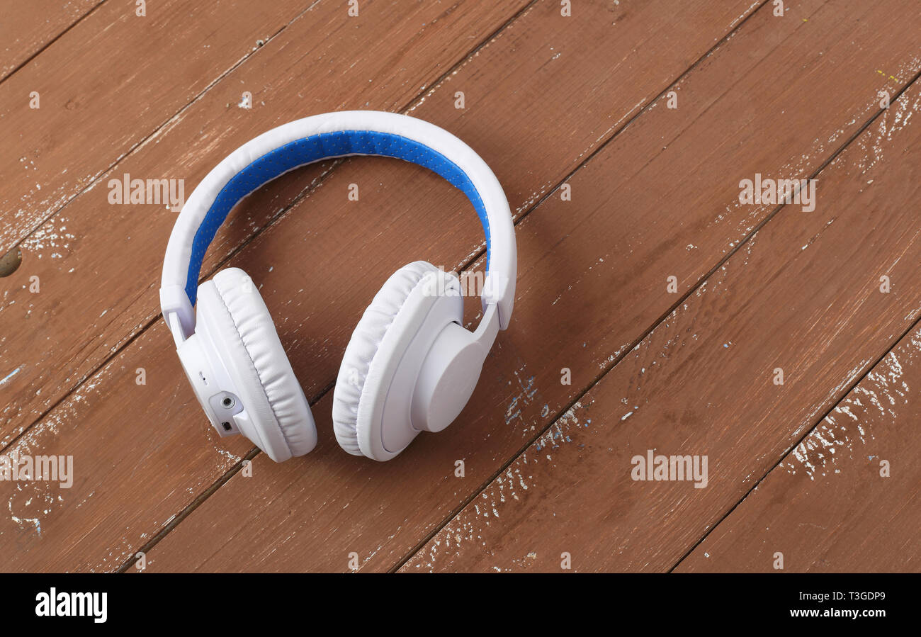 Matériel de musique - Blanc Bleu d'un casque sans fil sur un fond de bois. Banque D'Images