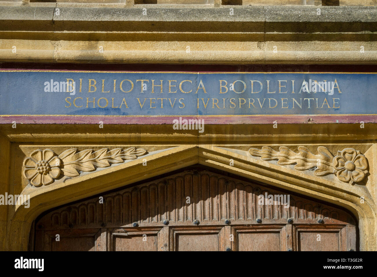 Une inscription latine au-dessus d'une porte en chêne à la Bodleian Library, Oxford dans l'ancienne école Quadrangle Banque D'Images