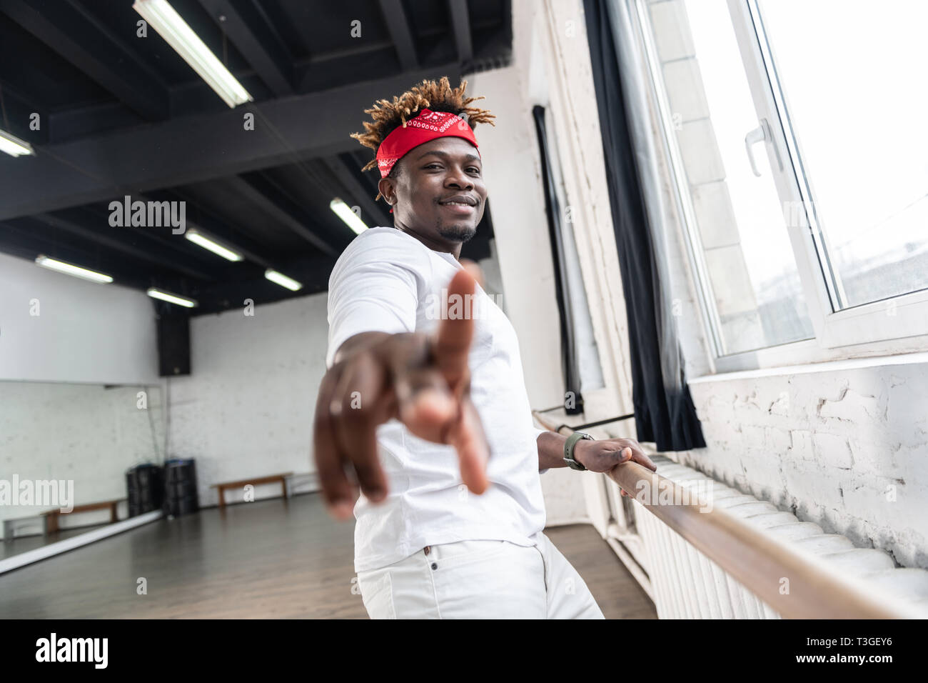 African American artistique guy dans tous les vêtements blancs s'appuyant sur support en bois Banque D'Images