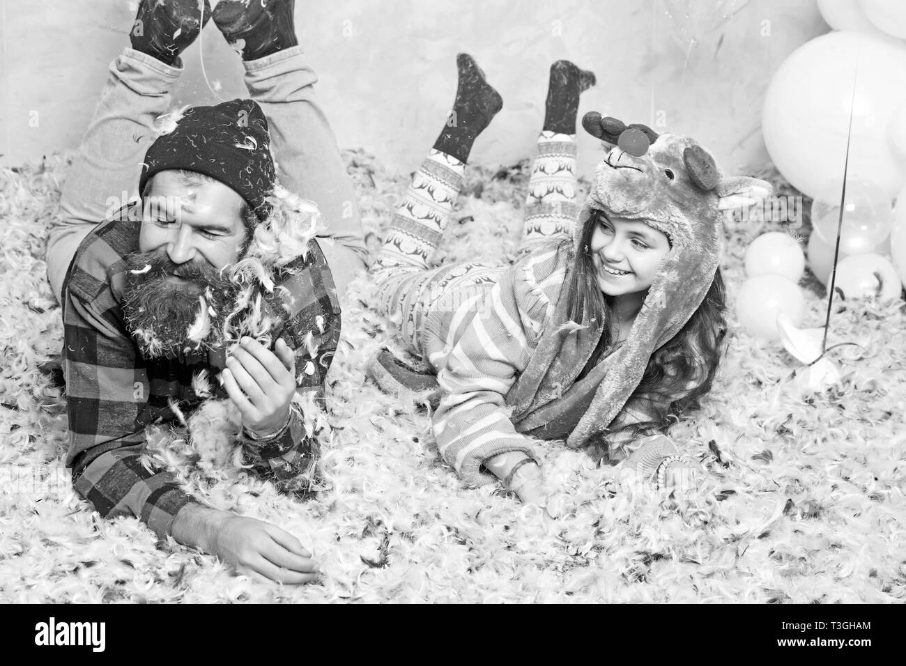 La famille Nouvel An se trouvent dans les plumes. Nouvelle année, père et fille fêter les vacances d'hiver Banque D'Images