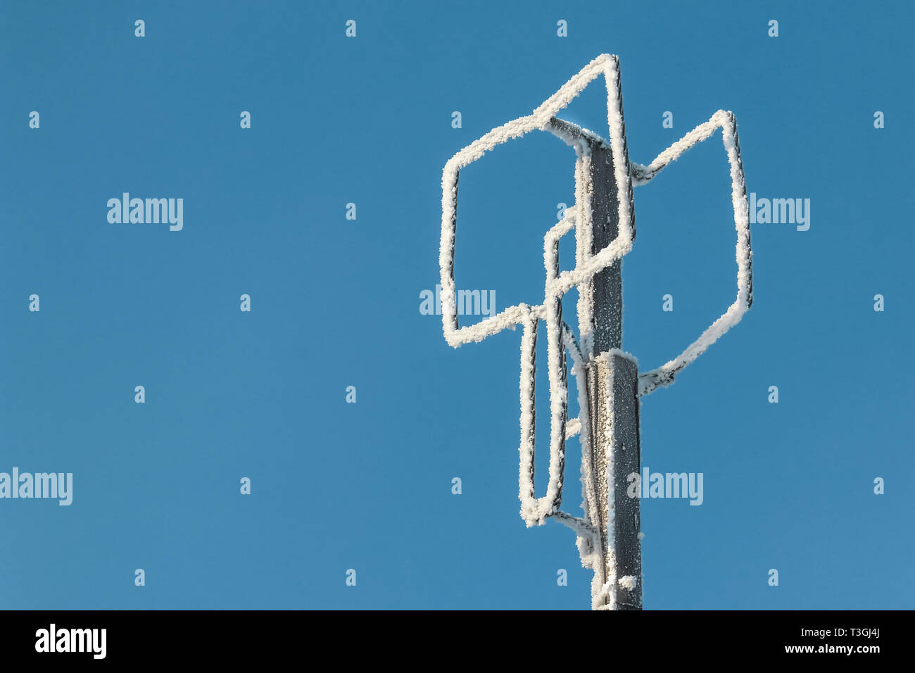 Self-made-antenne de télévision de fil aluminium contre un ciel bleu en hiver gel recouvert de givre et de neige Banque D'Images