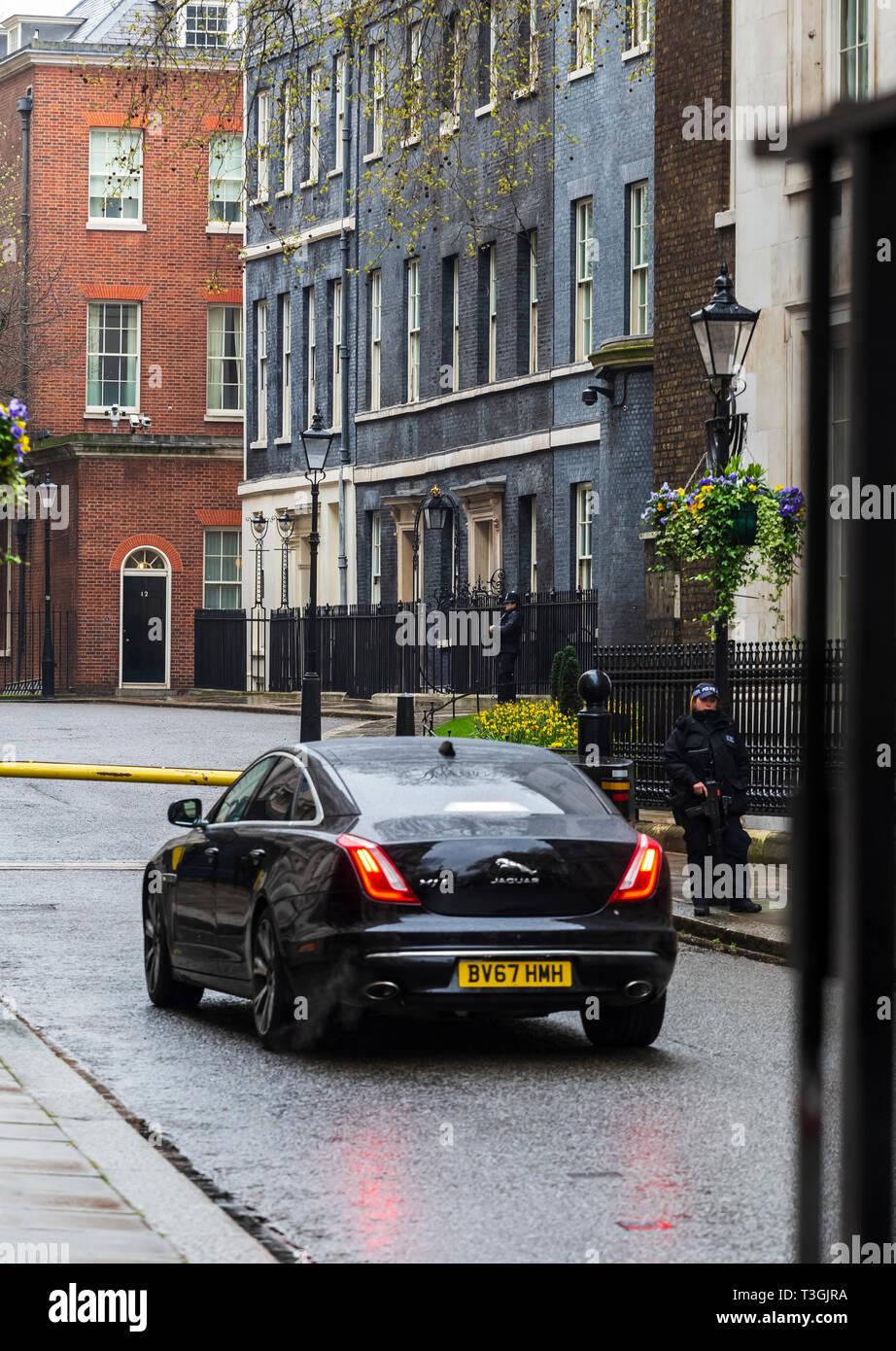 Voiture officielle du gouvernement entrant Downing Street aux forces de police sur la Garde côtière canadienne Banque D'Images