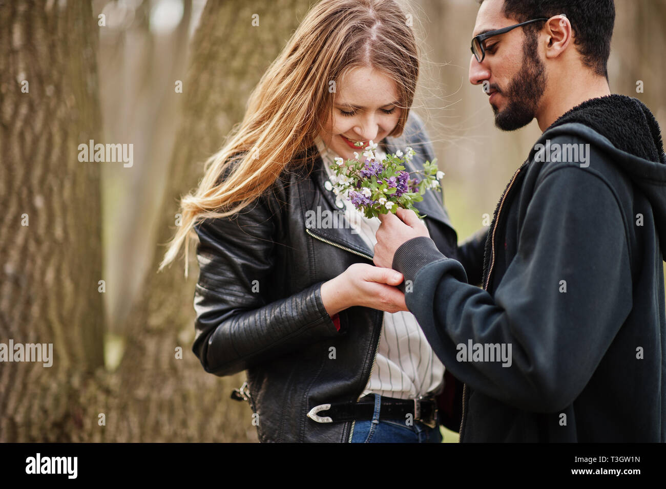 Histoire D Amour De Cool Couple Multiracial En Foret Au Printemps Homme Donne Des Fleurs Pour Sa Petite Amie Photo Stock Alamy