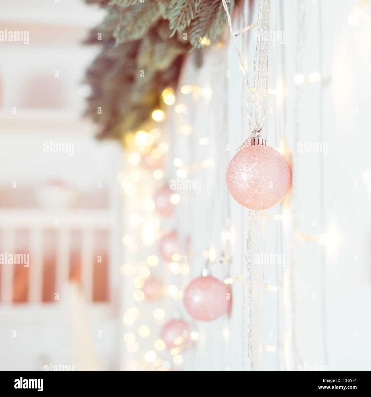 Décoration de Noël et Nouvel An. Selective focus on clair rose boules scintillantes guirlandes ang accroché sur la composition de la paroi. Arrière-plan de vacances de Noël Banque D'Images