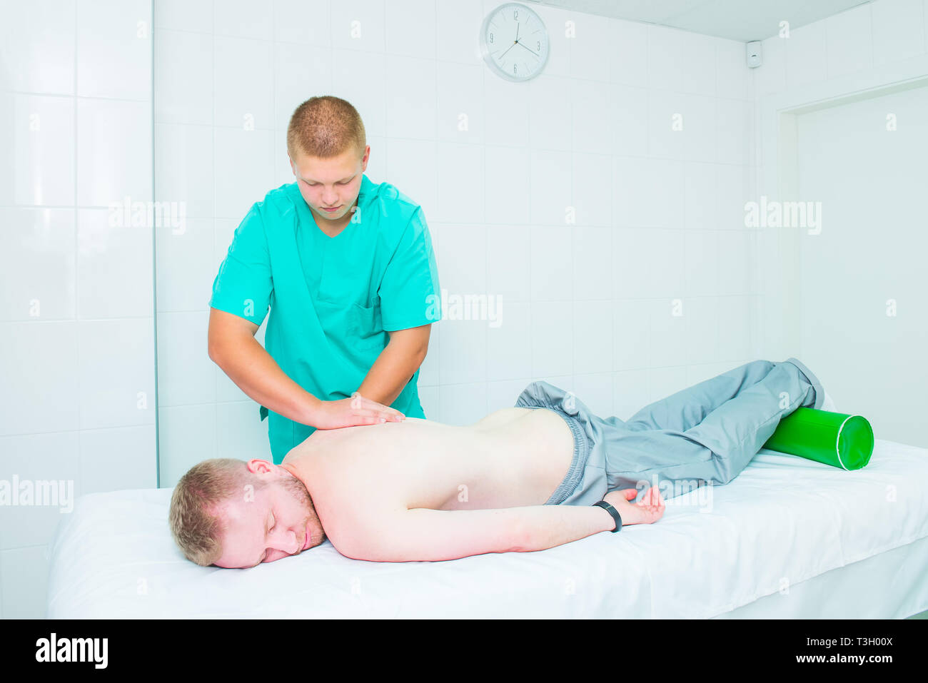 Patient recevant de massage thérapeute. Un chiropraticien ne massage tissus profonds sur l'homme en son épaule en cabinet médical. L'exa physique neurologique Banque D'Images