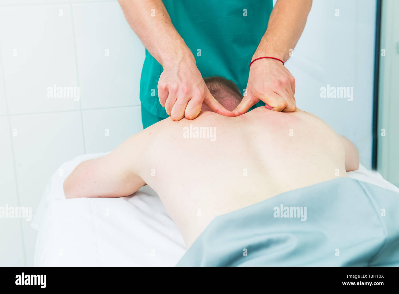 Patient recevant de massage thérapeute. Un chiropraticien ne massage tissus profonds sur l'homme en son épaule en cabinet médical. L'exa physique neurologique Banque D'Images