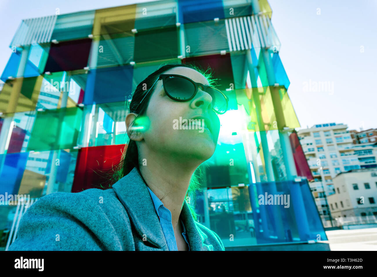 Espagne, Malaga - 04.04.2019 : portrait de femme résumé lunettes rayban à côté du cube coloré Centre Pompidou à Malaga, Espagne en soleil Banque D'Images