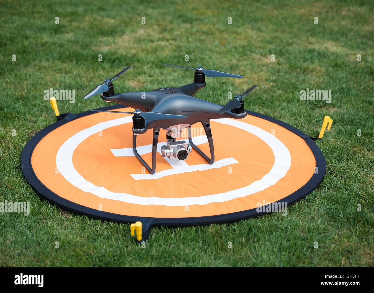 Vue de face d'un fantôme noir obsidienne Pro 4 DJI quadcopter drone sur une  plate-forme d'atterrissage orange entouré d'herbe Photo Stock - Alamy