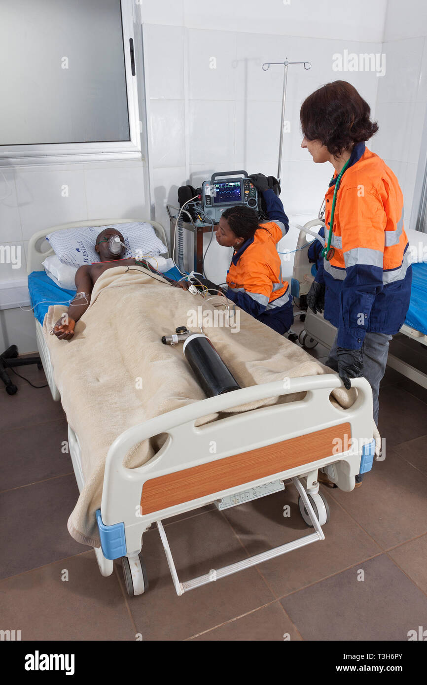 Centre médical avec des lits de soins intensifs et le patient sur l'oxygène défibrillateur portable montrant l'équipement et d'un ventilateur plus médecin et l'infirmière de paroisse Banque D'Images