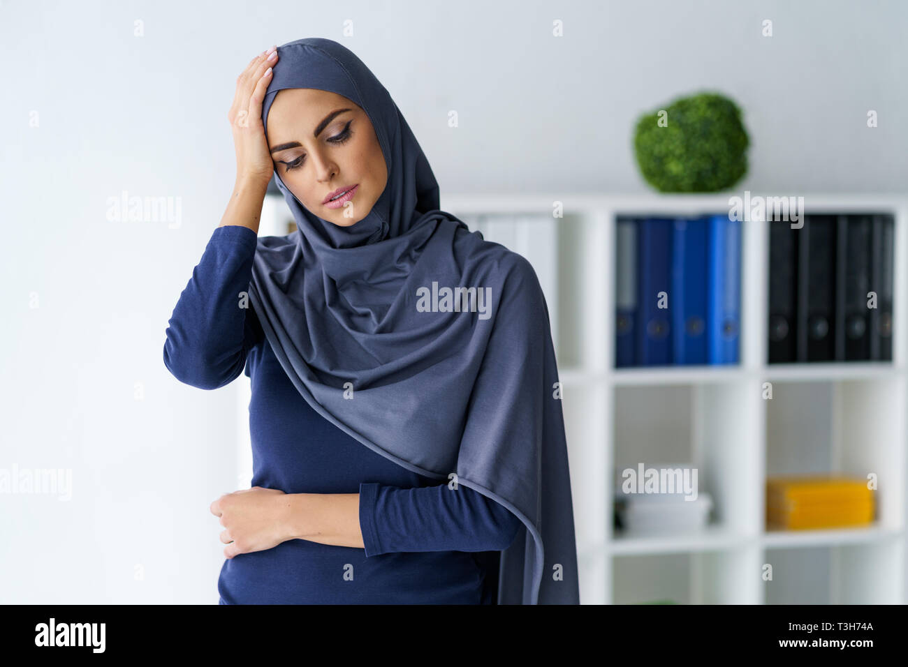 Femme musulmane ayant un mal de tête Banque D'Images