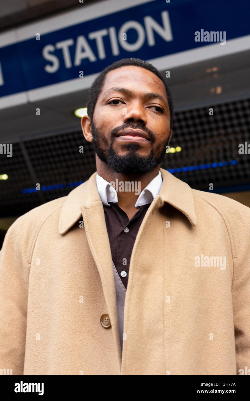 A black man posing in front of Brixton underground station au cours de la journée en décembre. L'homme juste fini de prêcher le christianisme dans les rues. Banque D'Images