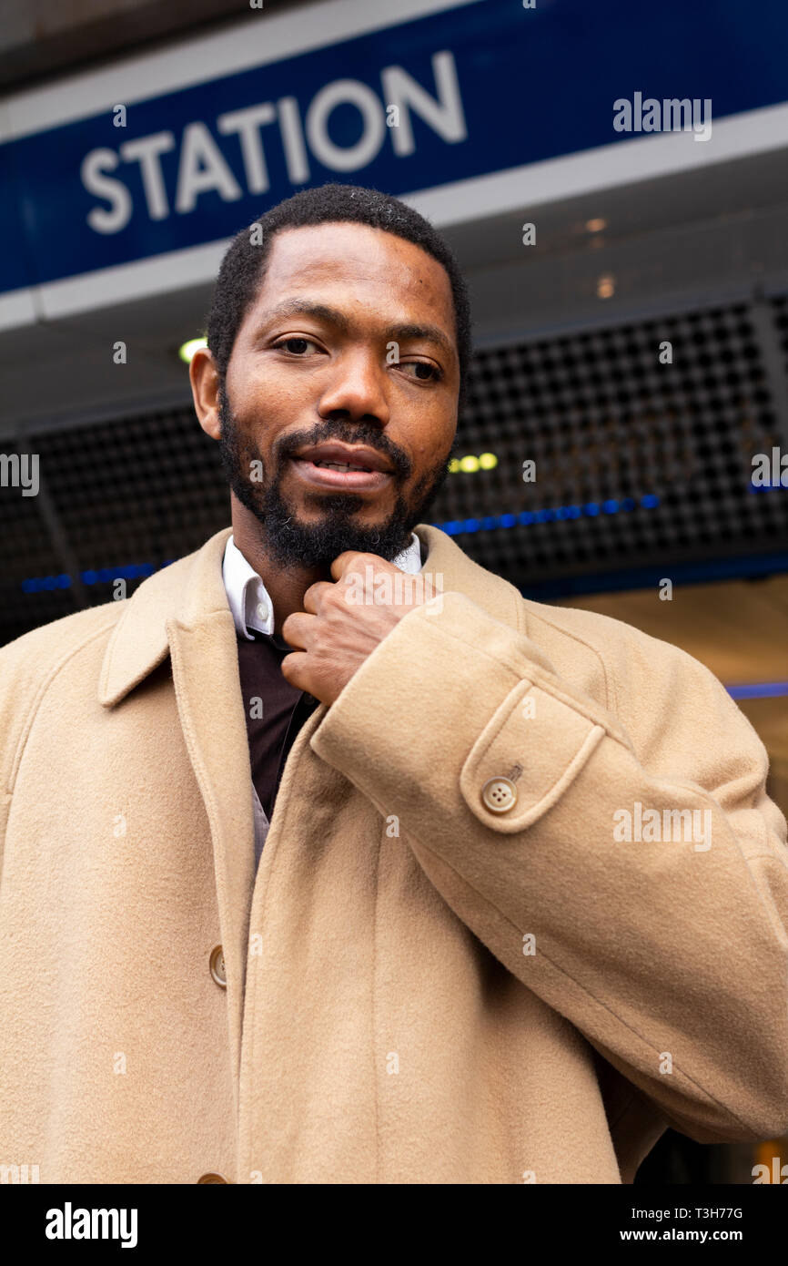 A black man posing in front of Brixton underground station au cours de la journée en décembre. L'homme juste fini de prêcher le christianisme dans les rues. Banque D'Images