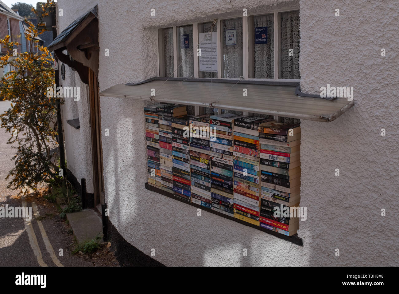 Lympstone, Devon, UK, avril, 8, 2019 : un tas de différents livres en vente sur un rebord de fenêtre dans un village dans le Devon, tout l'argent recueilli sert à financer l'embarcation locale Banque D'Images