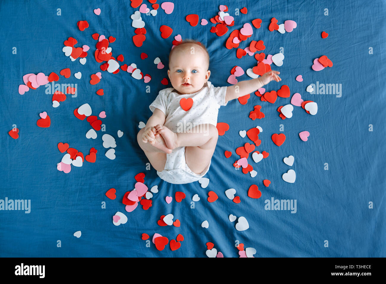 Cute Adorable Caucasian Baby Fille Garcon Bebe Aux Yeux Bleus De 4 Mois Lying On Bed Parmi Beaucoup De Papier Mousse Rose Rouge Coeurs Colores Voir Fr Photo Stock Alamy