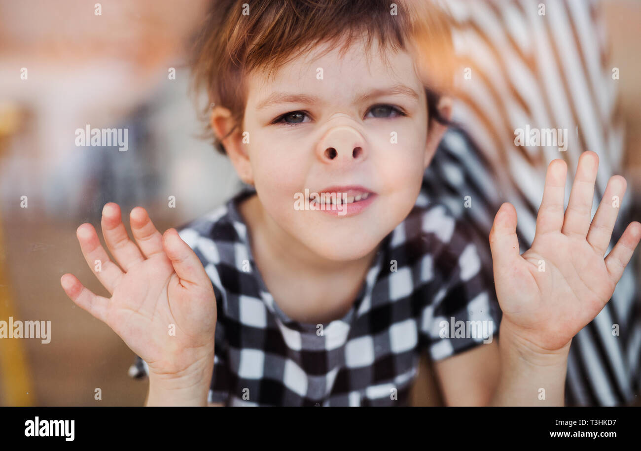 Un gros plan d'une petite fille en regardant par la fenêtre. Banque D'Images