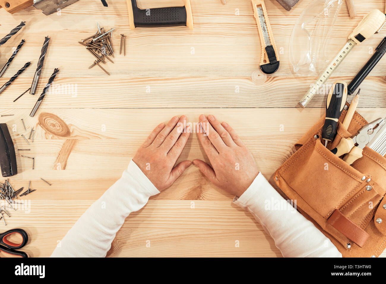 Female carpenter mains sur un bureau, vue du dessus avec divers outils de menuiserie menuiserie Banque D'Images