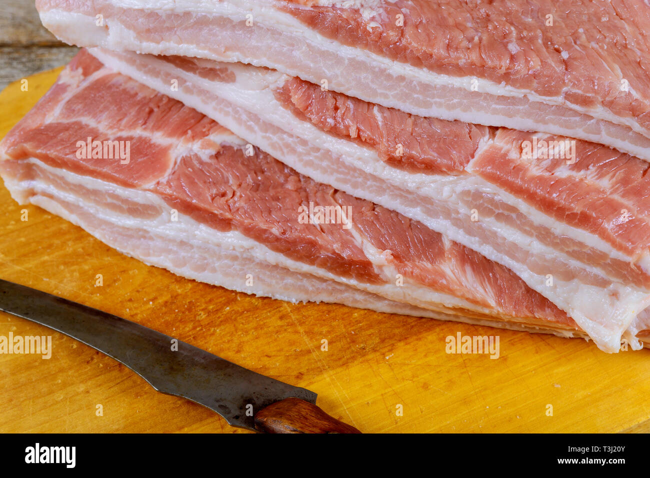 Matières premières fraîches bacon sur table en bois Banque D'Images
