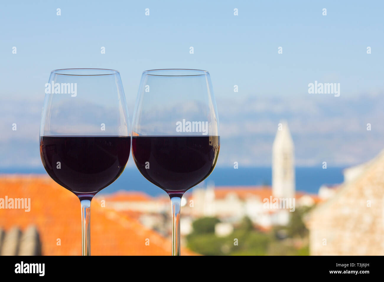 Deux verres de vin rouge à Terrace patio avec vue sur la ville un arrière-plan en Croatie Supetar , concept vin naturel croate Banque D'Images