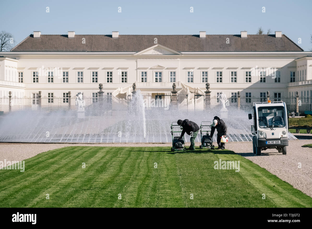 Hanovre, Allemagne. 01 avr, 2019. Les jardiniers Andre (l-r) et Oliver tondre la pelouse en face du château de Herrenhausen. Les jardins Herrenhäuser a enregistré un nombre record de visiteurs l'année dernière. Toutefois, certains projets de rénovation sont nécessaires. Environ 20 millions d'euros sont disponibles. C'est également d'être utilisés pour de nouvelles constructions. Credit : Ole Spata/dpa/Alamy Live News Banque D'Images
