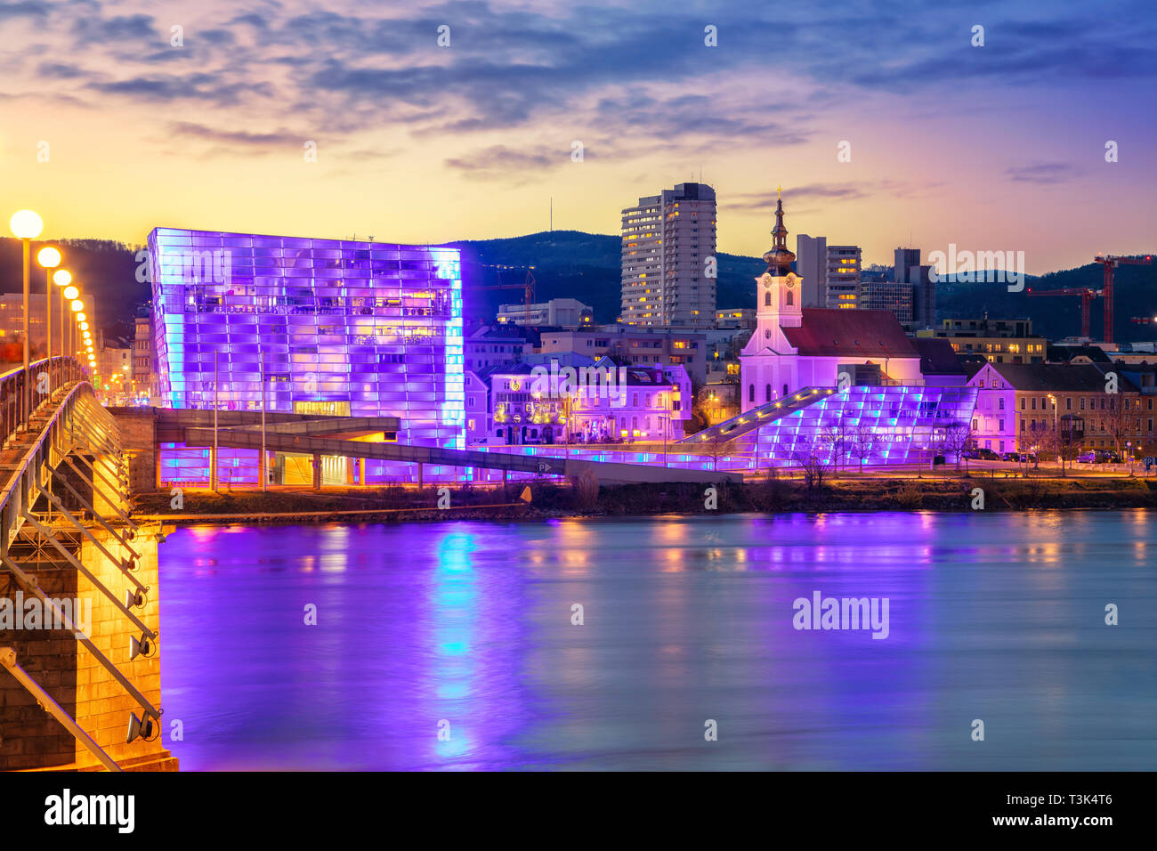 Linz, Autriche. Cityscape image de riverside Linz, Autriche pendant le crépuscule heure bleue avec la réflexion de la ville des lumières dans le Danube. Banque D'Images