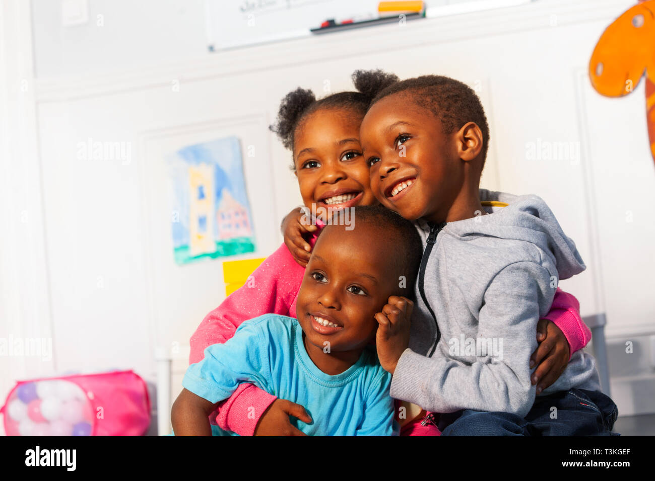 Trois happy little black kids fermer portrait hug Banque D'Images