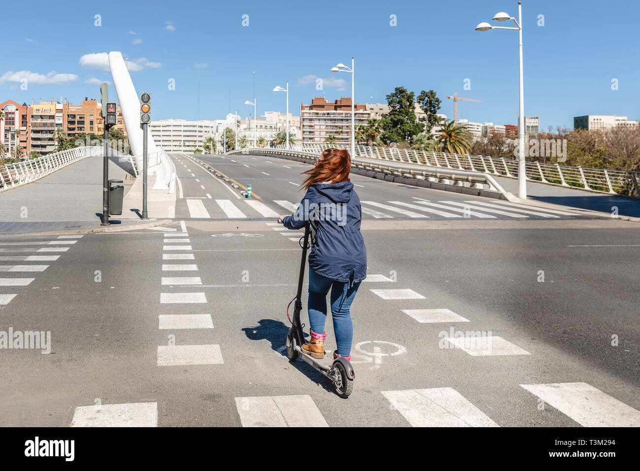 Femme sur scooter électrique traverser une rue sans voitures sur une piste  cyclable dans la ville de Valence Photo Stock - Alamy