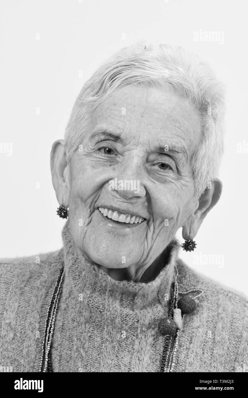 Portrait of a senior woman smiling sur fond blanc, noir et blanc Banque D'Images