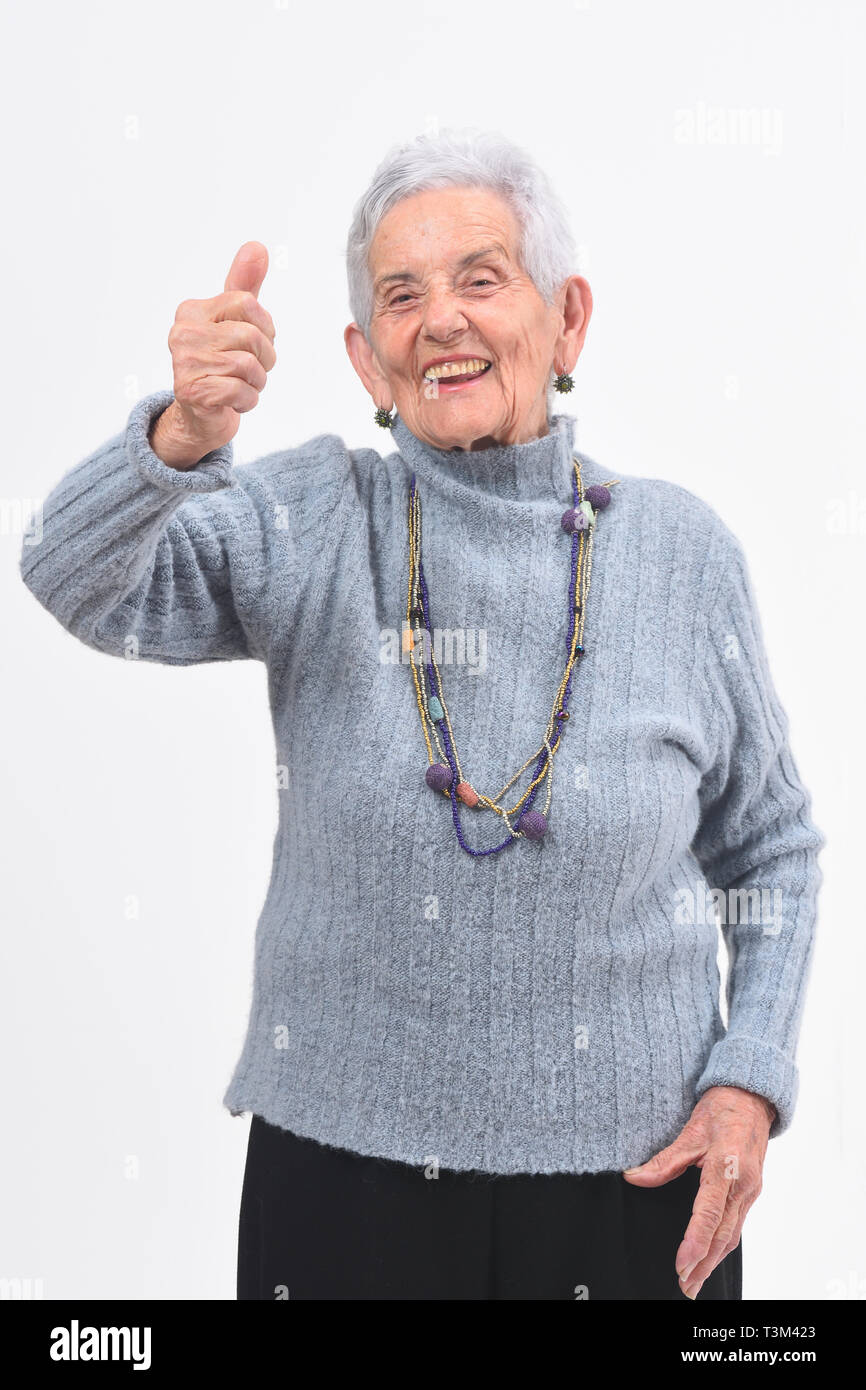 Femme plus âgée avec Thumbs up et sourire sur fond blanc Banque D'Images