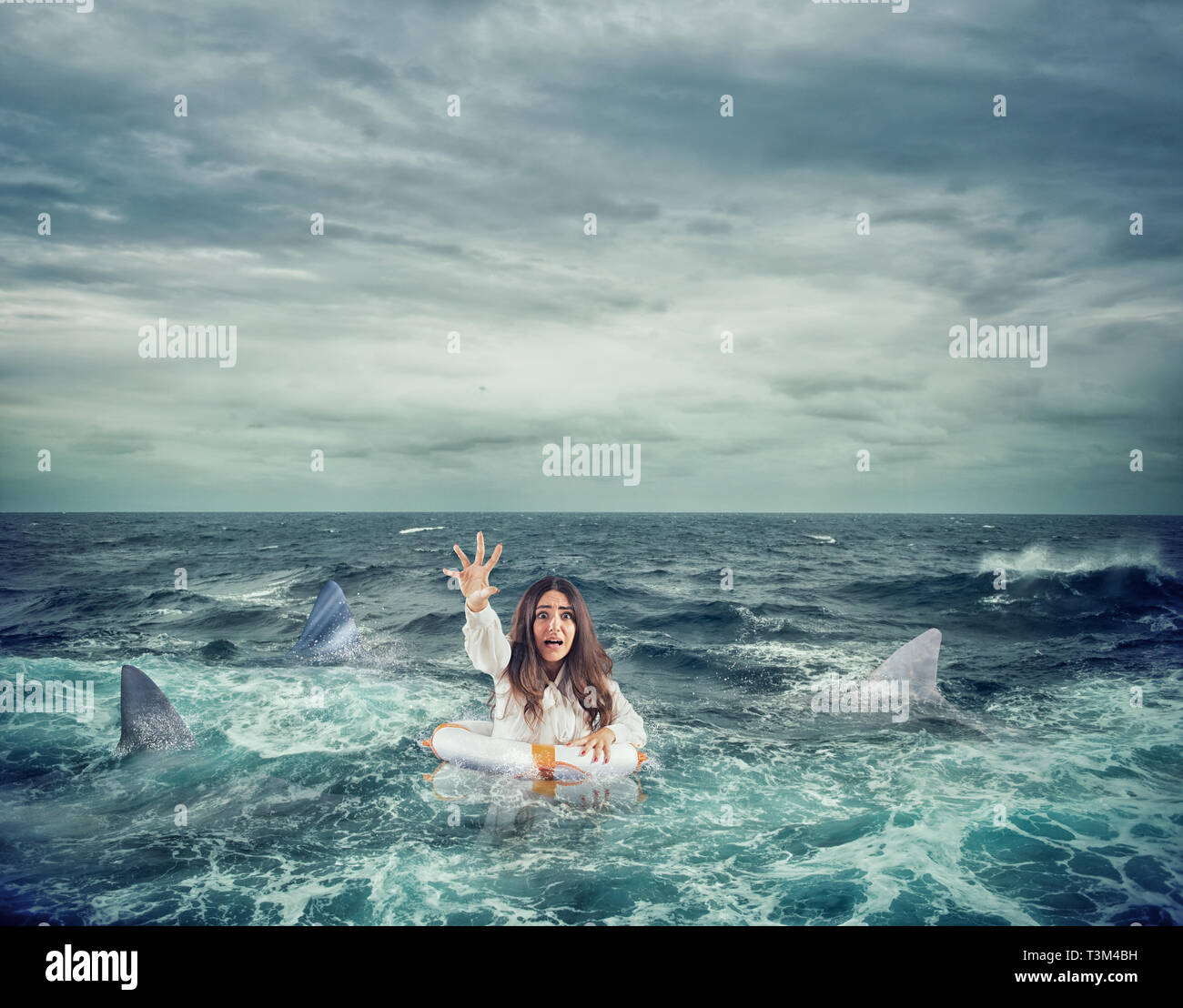 Businesswoman avec bouée entouré par des requins vous demande de l'aide Banque D'Images