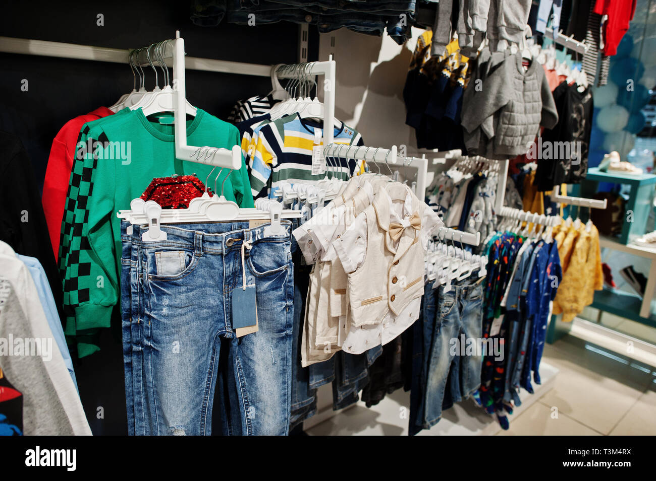 Enfants Vêtements lumineux de l'accrocher sur l'affichage dans le magasin de vêtements de bébé. La section des garçons. Banque D'Images