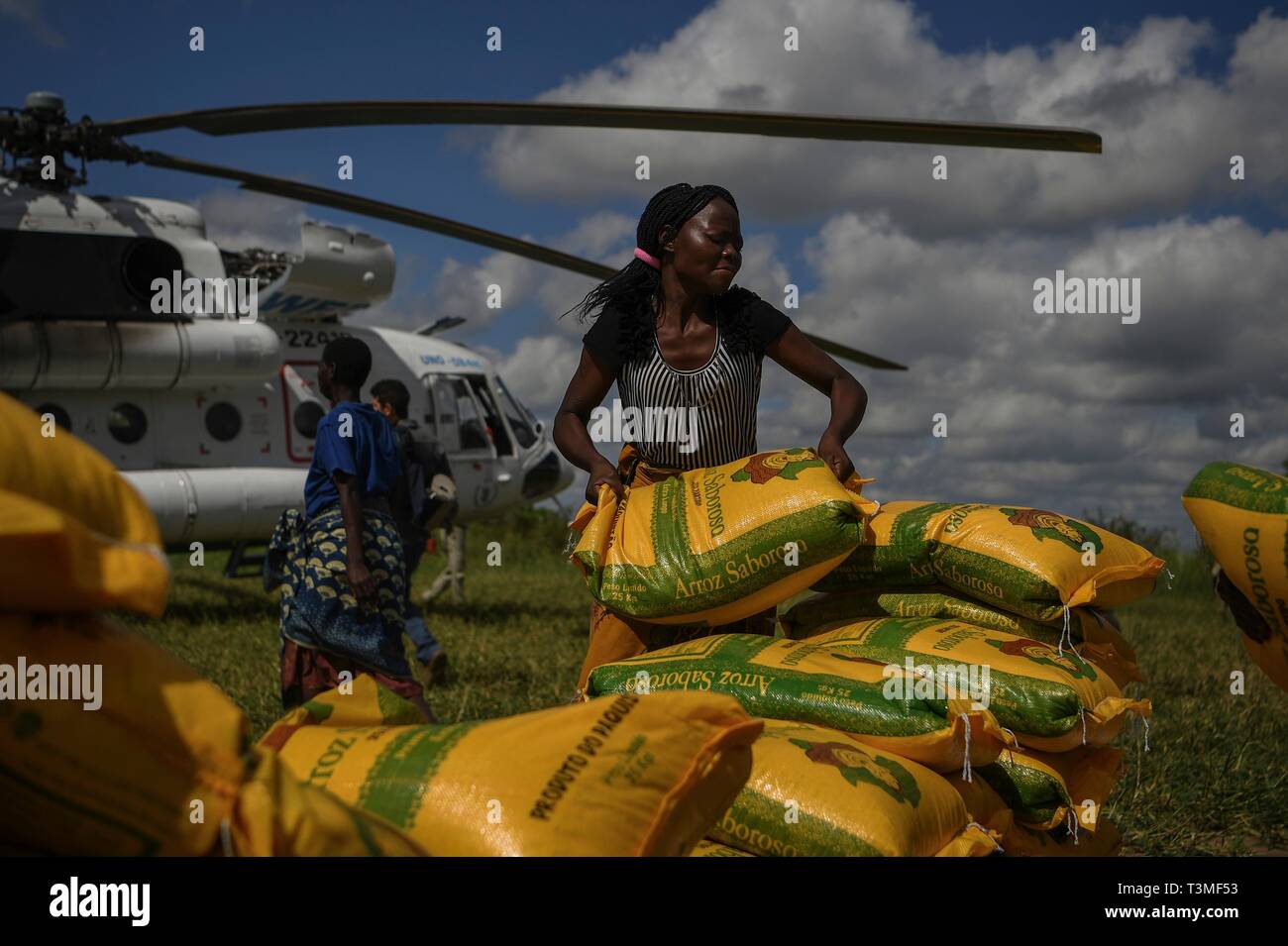 Des bénévoles de l'aider à décharger l'aide alimentaire d'un hélicoptère à la suite de l'Idai Cyclone massive le 8 avril 2019 près de Bebedo, au Mozambique. Le Programme alimentaire mondial, avec l'aide de l'US Air Force est de transporter du matériel de secours d'urgence pour aider la région dévastée. Banque D'Images