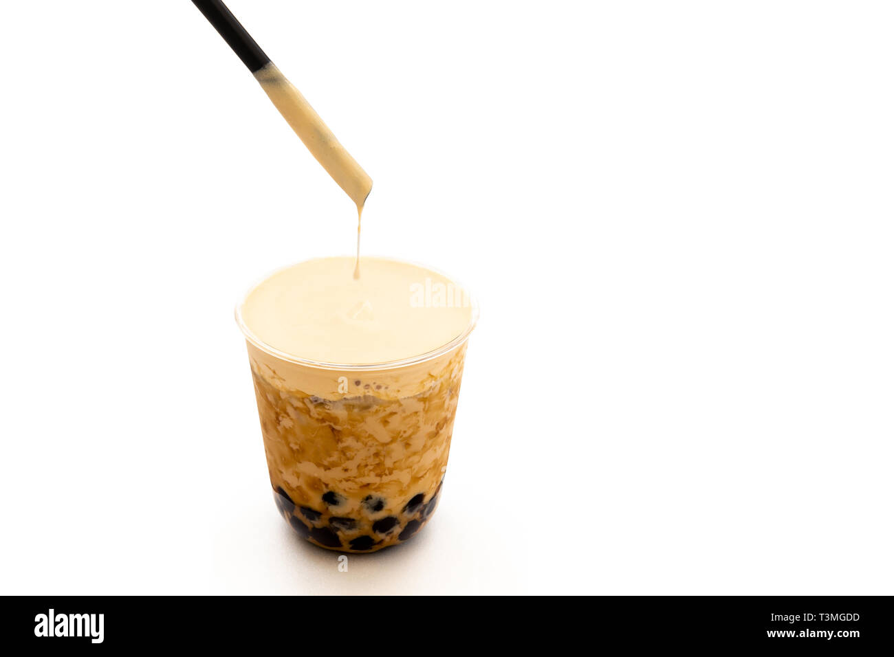 Thé glacé Lait perle avec de la crème sur le dessus isolé dans chemin de détourage. Banque D'Images