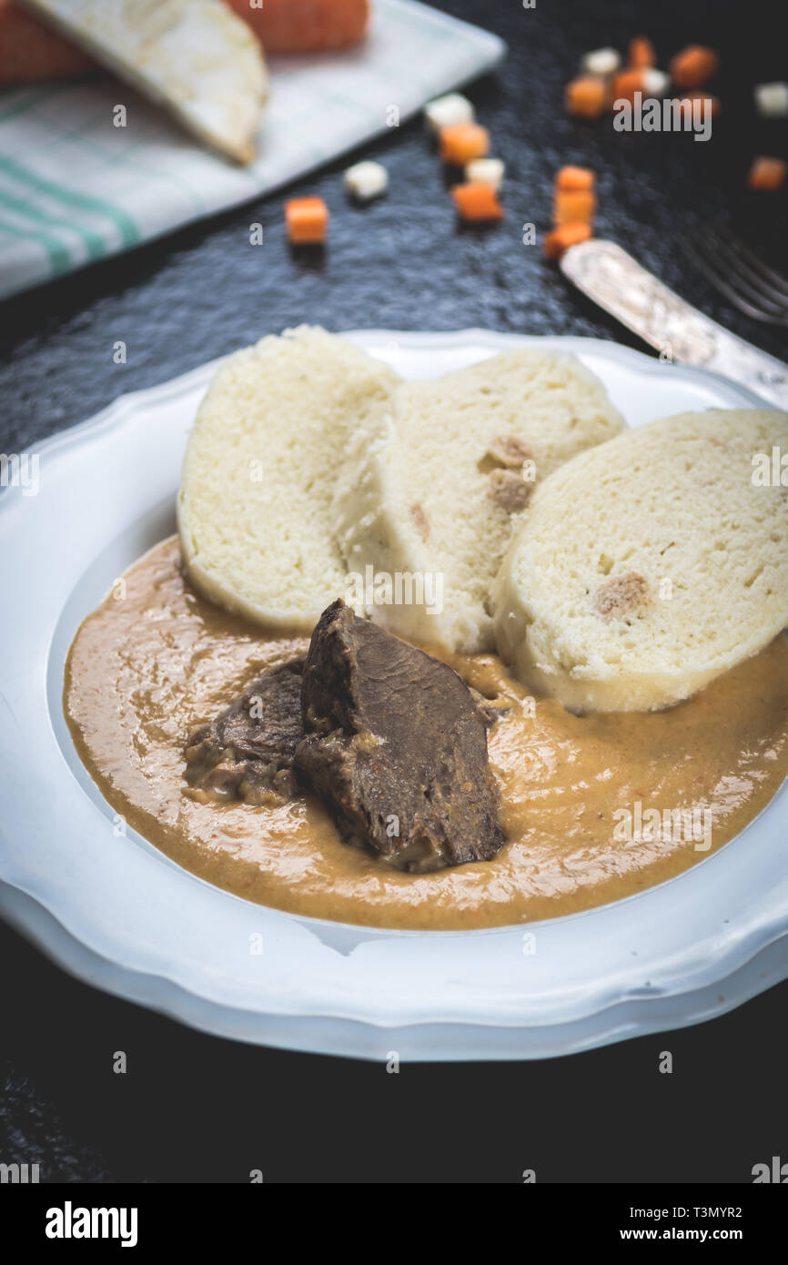 Cuisine tchèque, filet de boeuf et sauce crème et quenelles sur table en pierre noire Banque D'Images