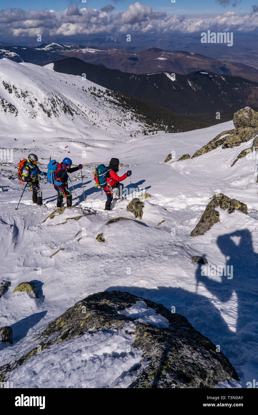 Groupe d'alpinistes gravir et atteindre le sommet de l'une des plus spectaculaires pics dans le Parc National Retezat, Roumanie Banque D'Images