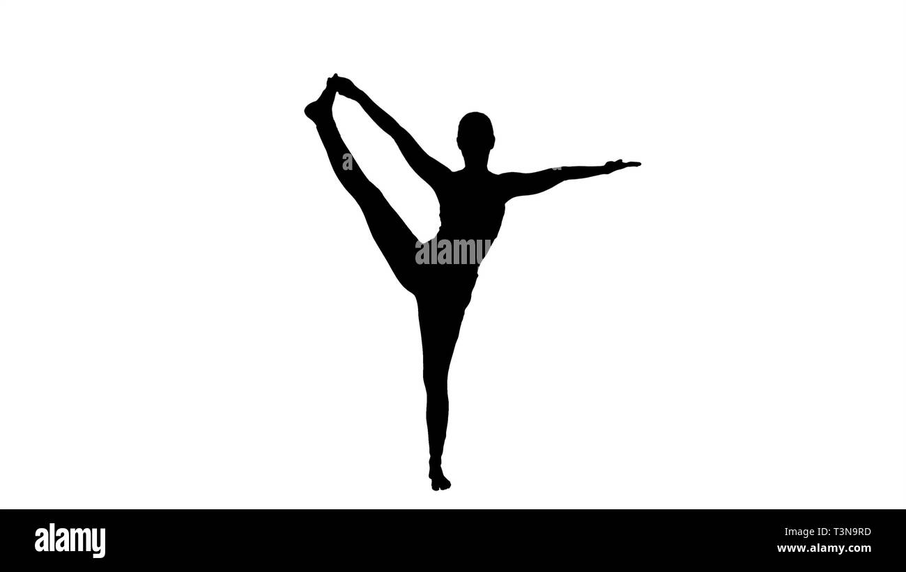 Silhouette Jeune femme pratiquant le yoga, debout dans Utthita Hasta Padangustasana l'exercice, la main tendue à la posture du gros orteil. Banque D'Images