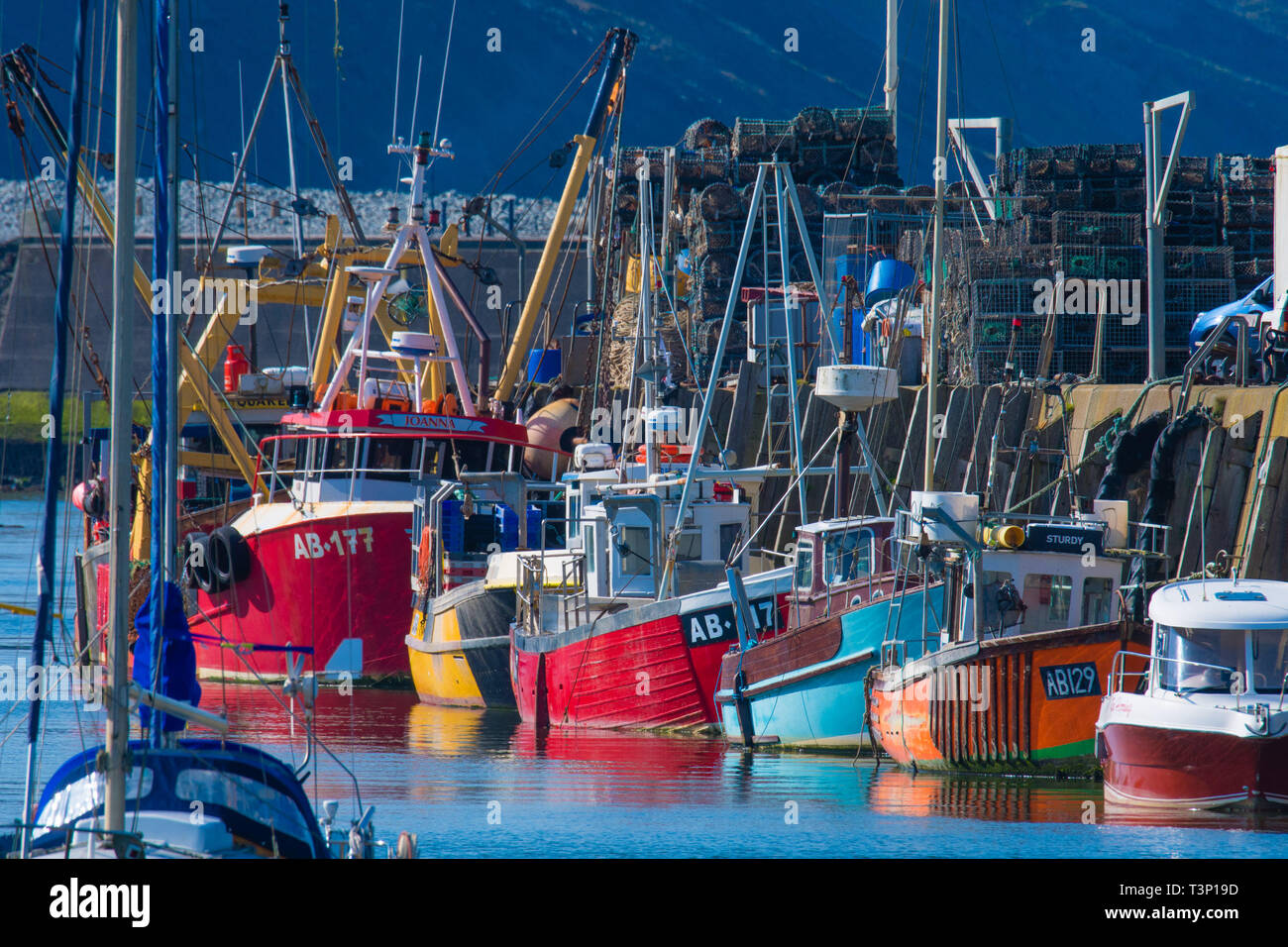 Aberystwyth, Pays de Galles, Royaume-Uni. Apr 11, 2019. Météo France : bateaux de pêche côtiers locaux alignés dans un arc-en-ciel de couleurs contre le mur du port sur un matin lumineux et ensoleillé à Aberystwyth, sur la côte ouest de la Baie de Cardigan au Pays de Galles. crédit : Keith morris/Alamy Live News Banque D'Images