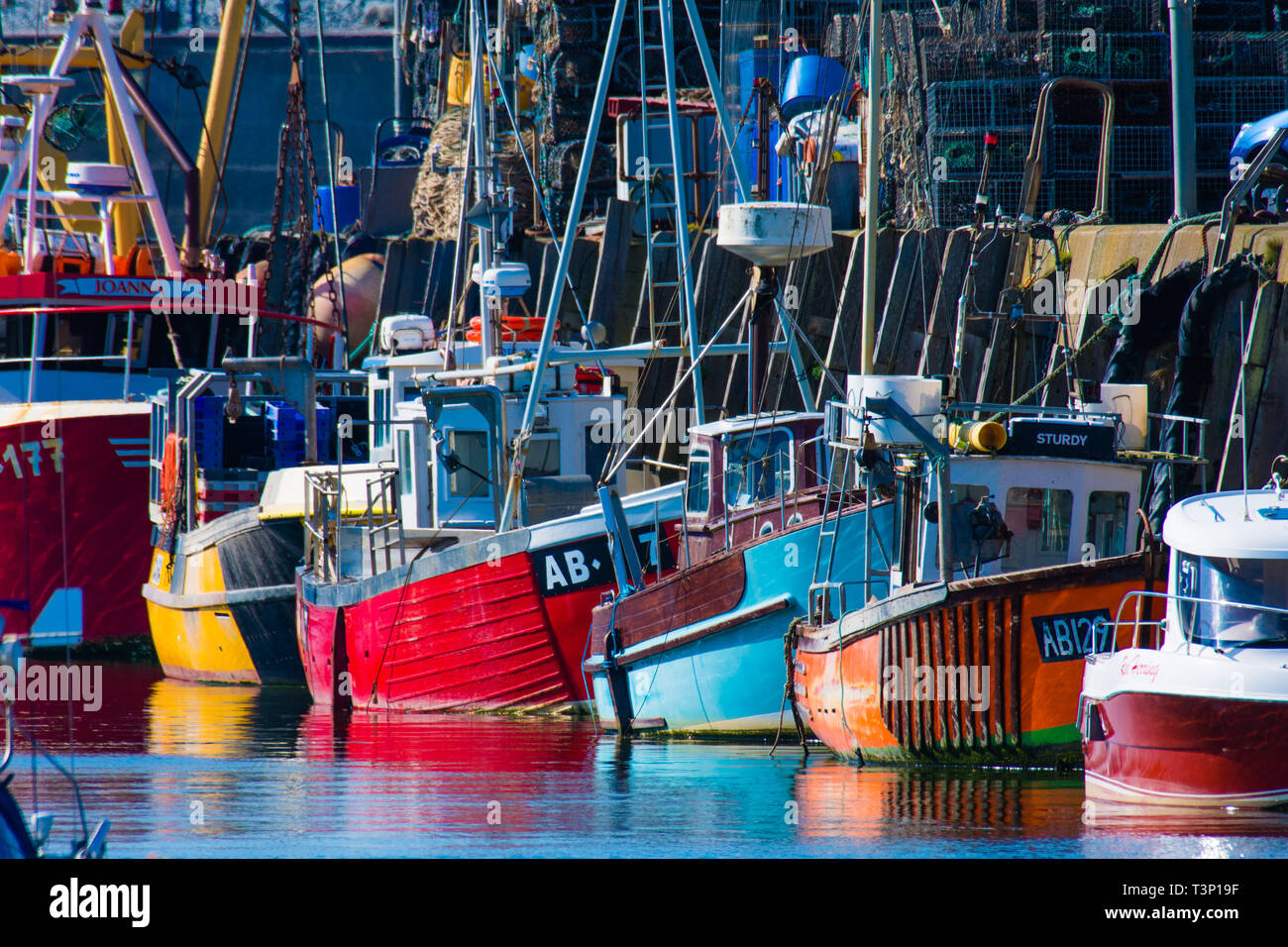 Aberystwyth, Pays de Galles, Royaume-Uni. Apr 11, 2019. Météo France : bateaux de pêche côtiers locaux alignés dans un arc-en-ciel de couleurs contre le mur du port sur un matin lumineux et ensoleillé à Aberystwyth, sur la côte ouest de la Baie de Cardigan au Pays de Galles. crédit : Keith morris/Alamy Live News Banque D'Images