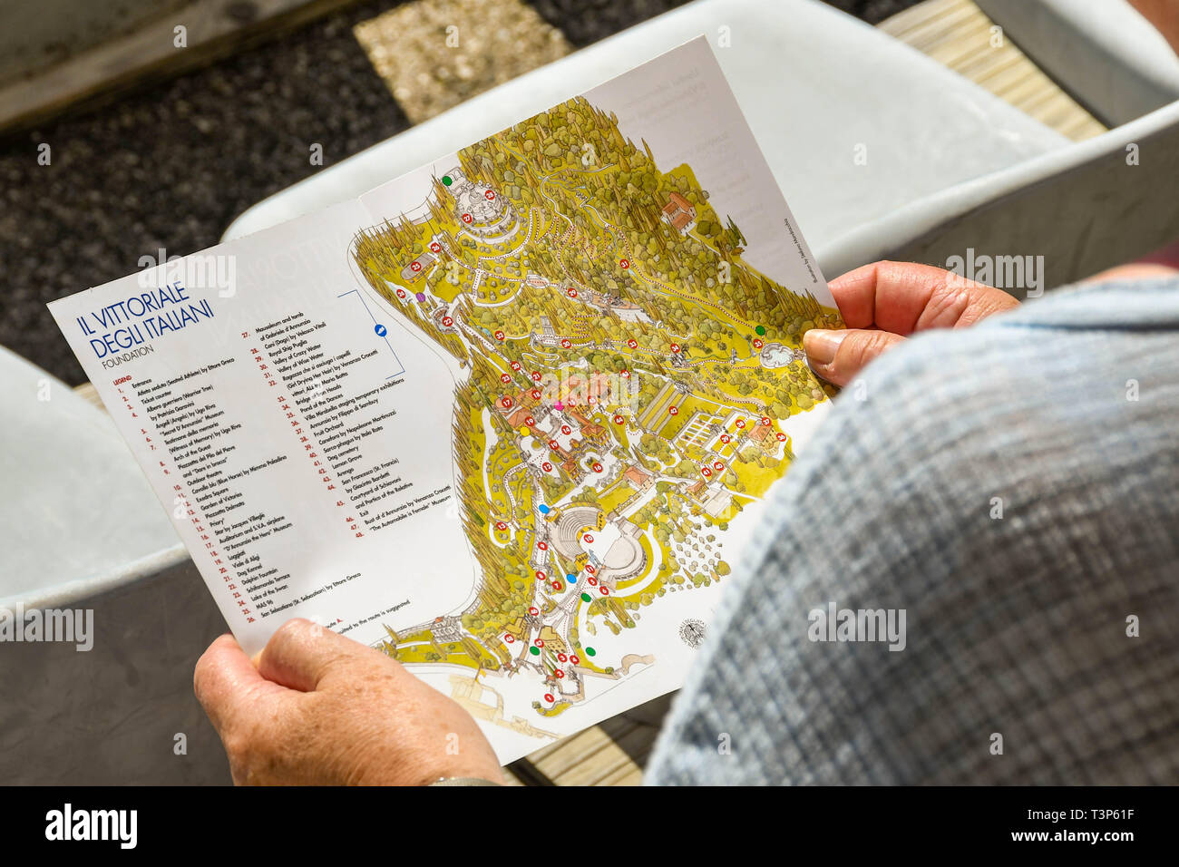 GARDONE RIVIERA, ITALIE - Septembre 2018 : Visiteur en regardant une carte du Vittoriale degli Italiani gardens à Gardone Riviera. Banque D'Images