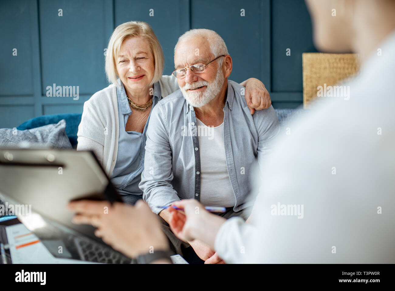 Happy senior couple lors de la réunion avec l'agent ou conseiller financier, la signature d'un accord dans le bureau confortable Banque D'Images